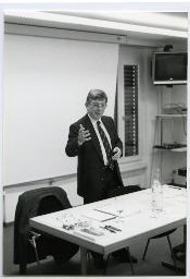 Alfred Meyer präsentiert etwas an einem Tisch vor einer Leinwand, Jugendkonferenz Olten, 27. Oktober 1990