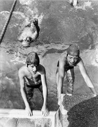 Zwei Kinder halten sich am Rand eines Schwimmbades und behalten ihre Beine im Wasser - Eine Person schwimmend, Magliaso 1978