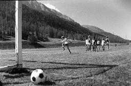 Fussballplatz - Kinder warten vor dem Tor, um den Ball zu schiessen, vermutlich Zuoz, 1979