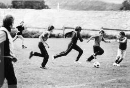 Kinder spielen Fussball im Freien