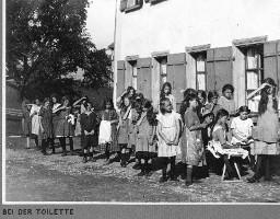 Bei der Toilette - Mädchen vor dem Ferienkoloniehaus mit Handtüchern, Waschlappen, Haarkämmen: Waschen und frisieren