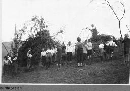 Bundesfeier - Kinder und Erwachsenen schichten Äste und Holzstücke auf - Holzstapel
