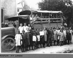 Ausflug mit Camion - Mädchen und Knaben sitzen im Camion und stehen vor dem Camion