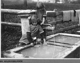Am Koloniebrunnen - Zwei Mädchen spielen mit dem Wasser und ein gebasteltes kleines Floss