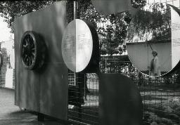 SAFFA 1958: "Das Rad der Zeit dreht sich weiter, es gibt kein zurück - Die Welt ist anders geworden" - Wand mit Wagenrad, Texttafeln und Spiegel mit Spiegelbild einer Frau; Zürich
