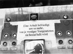 Schalttafel mit Zettel: "Eine Arbeit befriedigt um so mehr, von je weniger Vorgesetzten sie beeinflusst wird."
