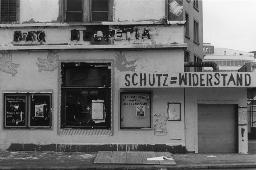 Versprayte Hausfassade des "Hotel Restaurant Bar Helvetia"; Sprayerei "Schutz = Widerstand"; Notiz auf Rückseite: "Abbruch Objekt"; Badenerstrasse Zürich, um 1970