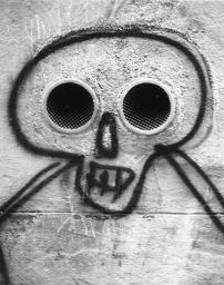 Sprayerei - Totenkopf mit Entlüftungsfenster als Augen; beim Rosenhof in Zürich; um 1980