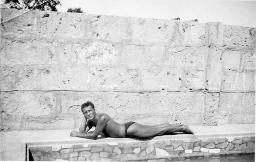 Bob Steffen in Badehose vor Quaimauer liegend, um 1955