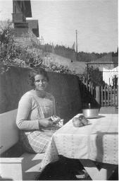 Junge unbekannte Frau mit Schürze, rüstet draussen an Tisch Früchte, um 1950
