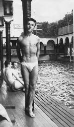 Unbekannter junger Mann in Badehose lehnt sich an Pfeiler in «Piscine» (Piscine Molitor, Paris?), um 1950