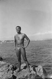 Bob Steffen in Badehose auf Klippe am Meer, Hände auf die Hüfte gestützt, um 1950