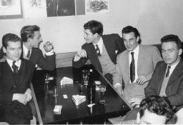 Bob Steffen (Mitte) mit hellem Gilet, Kravatte, dunkle Jacke mit unbekannten Männern in Restaurant, um 1955