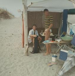Zelten in der Camargue, Bob Steffen im weissen Hemd und Hund «Jet», Gerard Kuiper in gestreiftem Oberteil, Vordach Zelt, 1966