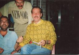 Gerard Kuiper mit Schnauz und Brille beugt sich über Tisch, mit Klaas und Unbekanntem, 1991