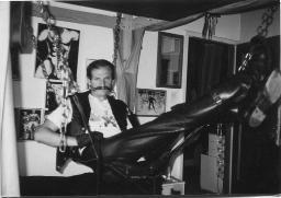 Fernand Widolff mit Schnauz; ganz in Leder und Stiefeln, in einem Kettengestell, 1985