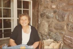 Unbekannte Frau sitzt vor Mauer, 1983