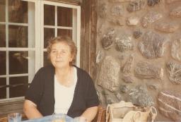 Unbekannte Frau sitzt vor Mauer, 1983