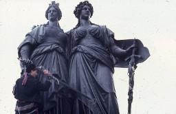 Aktivistin auf Statue; ILIS (International Lesbian Information Service) Konferenz Genf 1986