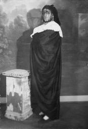 Bob Steffen als Hamlet vor gemaltem Bühnenbild in Stola gehüllt, um 1955