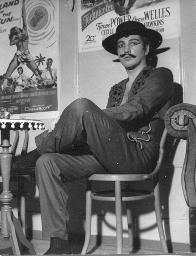 Bob Steffen als Westernheld auf Stuhl vor Filmplakaten, Kostümparty, 1958
