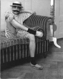 Als Sträfling oder Matrose verkleideter Mann mit Schnauz auf Sofa; Sommerhut, nackte Beine, Espadrilles; Kostümparty, 1958