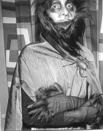 Meret Oppenheim mit Affenhaar-Perücke, Cape und Spinne als Schnalle, Brustbild; Kostümparty, 1958