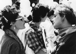 Zwei stark geschminkte Frauen, im Hintergrund weisse Luftballone, auf Maske der Aufdruck: Hetero Garanti (e) 4.8.81; evt. in der Romandie