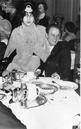 Bob Steffen mit Perlendiadem im wilden Haar, Deux-pièces; sitzt auf Schoss eines Unbekannten; Kostümparty, um 1960