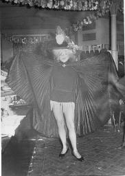 Bob Steffen stehend in Gay Bar mit Umhang (offen) und Kopfschmuck, um 1960