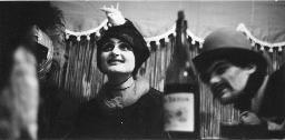 Ursula Werder Jeker mit Fantasiehut mit aufgesetztem Vogel und unbekannten Personen; Kostümparty, 1960