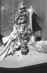 Schaufenster von «Ciolina» mit Putto und Streifenmuster, dazu ein Hinweis für eine Modeschau