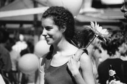 Frau mit lockigen Haaren und mit Blume am Rucksack; Christopher Street Day 1998 in Bern