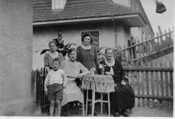 Familienmitglieder, vier Frauen, Bub in kurzen Hosen; vor Haus, 1933