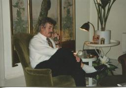 Bob Steffen sitzt im Salon seiner Wohnung an der Gutenbergstrasse in Bern vor Paravent mit Pfau, telefoniert, 1992