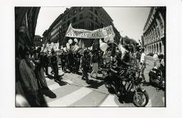 Demonstranten auf Strasse mit Plakaten, im Vordergrund schwarz angezogene Männer auf Motorrädern; Christopher Street Day 1998 in Bern