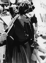 Verkleidete Frau mit Wäscheklammern im Haar, Sonnenbrille und Papiermaske im Gesicht; wahrscheinlich Hetero Garanti(e) 04.08.1981