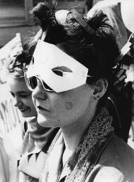 Verkleidete Frau mit Wäscheklammern im Haar, Sonnenbrille und Papiermaske im Gesicht; wahrscheinlich Hetero Garanti(e) 04.08.1981