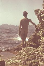 Bob Steffen nackt von hinten fotografiert, an Felsen abstützend, Gischt von Brandung, um 1950
