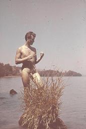 Aktfoto Bob Steffen in klassischer Stehposition im Schilf, betrachtet Schilfrohr, um 1950