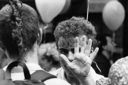 Gesichtsaufnahme eines bemalten Mannes, im Hintergrund weisse Ballone; Demonstration 24.06.1989 zu 20 Jahre Stonewall während der Aktion "20 Tage lesbisch-schwule Kultur" 09.06 - 01.07.1989 in Zürich