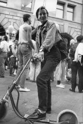 Frau mit kurzen Haaren und Hut auf einem Trettroller; Demonstration 24.06.1989 zu 20 Jahre Stonewall während der Aktion "20 Tage lesbisch-schwule Kultur" 09.06 - 01.07.1989 in Zürich