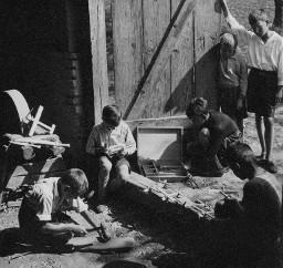 ...der Holzschopf ist in eine Schnitzlerwerkstätte verwandelt - Kinder im Freien am Schnitzen