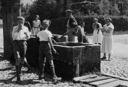 Kinder und Erwachsenen beim Brunnen - Kopfsteinpflaster