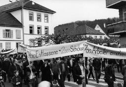 Menschenmenge demonstrierend - Transparent mir der Beschriftung: "700 Entlassene = 2000 Schicksale"