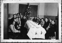 Album Alfred Brauchli, Teil 3/3, Ärzte- und Pflegermission des Schweizerischen Roten Kreuzes an der Ostfront, Winter 1942/1943: "Weihnachtsfeier der Schweizer Ärztemission, Gruppe Rostow", Fredy Brauchli (rechts) - [auf der Rückseite die Namen der Anwesenden vermerkt]