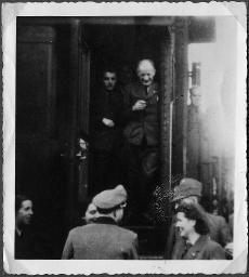 Album Alfred Brauchli, Teil 3/3, Ärzte- und Pflegermission des Schweizerischen Roten Kreuzes an der Ostfront, Winter 1942/1943: vermutlich Uniformierte der Wehrmacht des Deutschen Reiches und Mitglieder des Schweizerischen Roten Kreuzes (siehe Feldmützen mit Schweizerkreuz) bei einem Zugwaggon