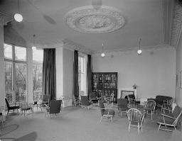Aufenthaltsraum mit Stühlen und kleinen Tischen, Bücherschrank, um 1950