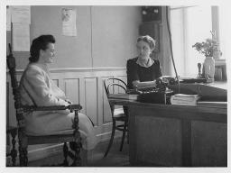 Zwei Frauen in einem Raum an einem Tisch sitzend, um 1940