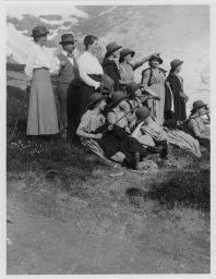 Gruppenporträt, mehrere Frauen, Männer und Kinder auf einer Wiese in den Bergen, um 1920